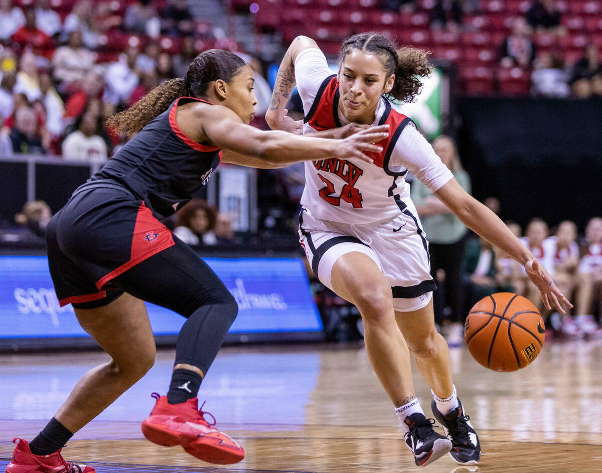 UNLV guard Essence Booker (24) drives the land against San Diego State guard Asia Avinger (1) d ...