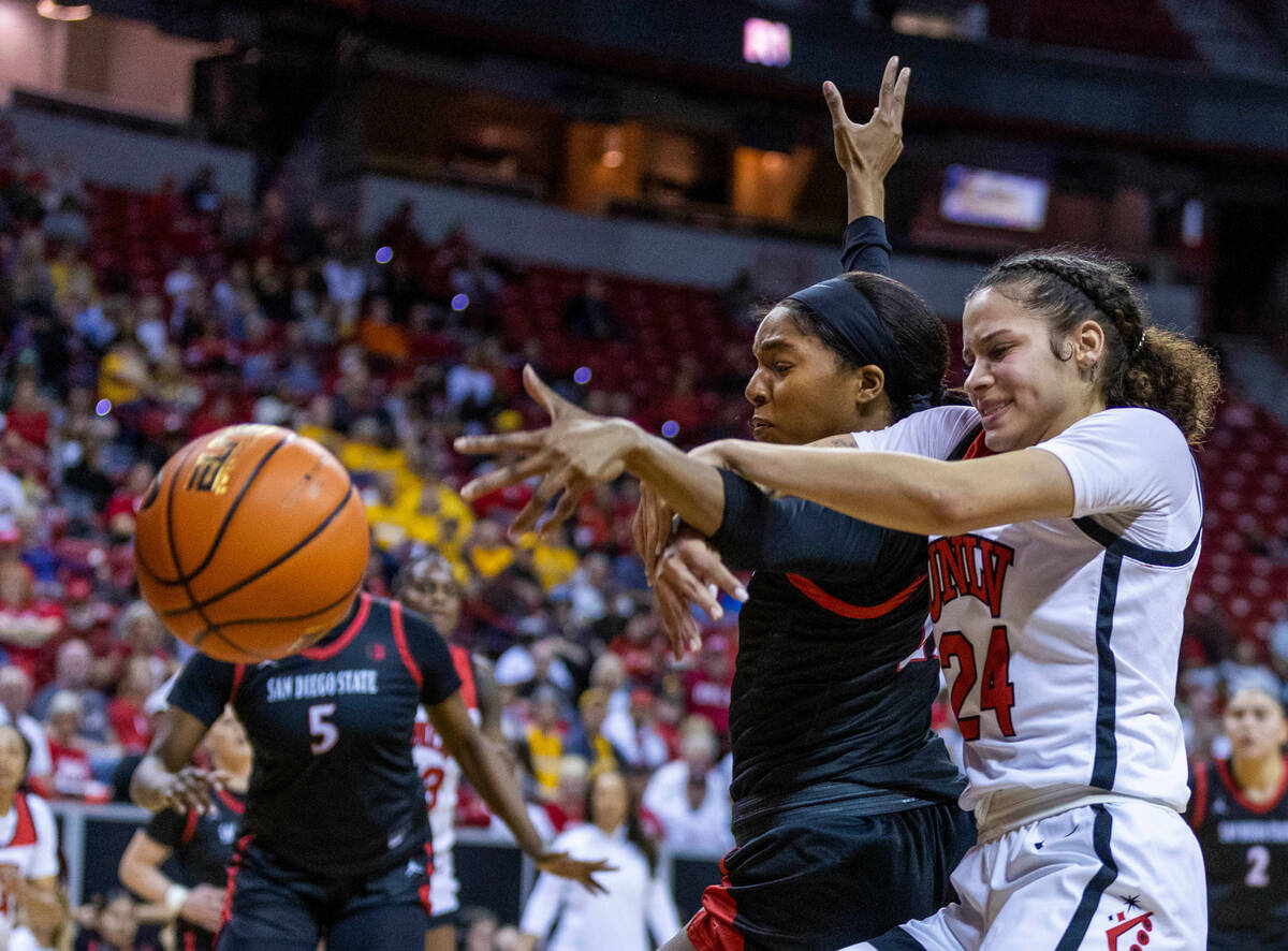 UNLV guard Essence Booker (24) and San Diego State guard Alex Crain (21) fight for a loose ball ...