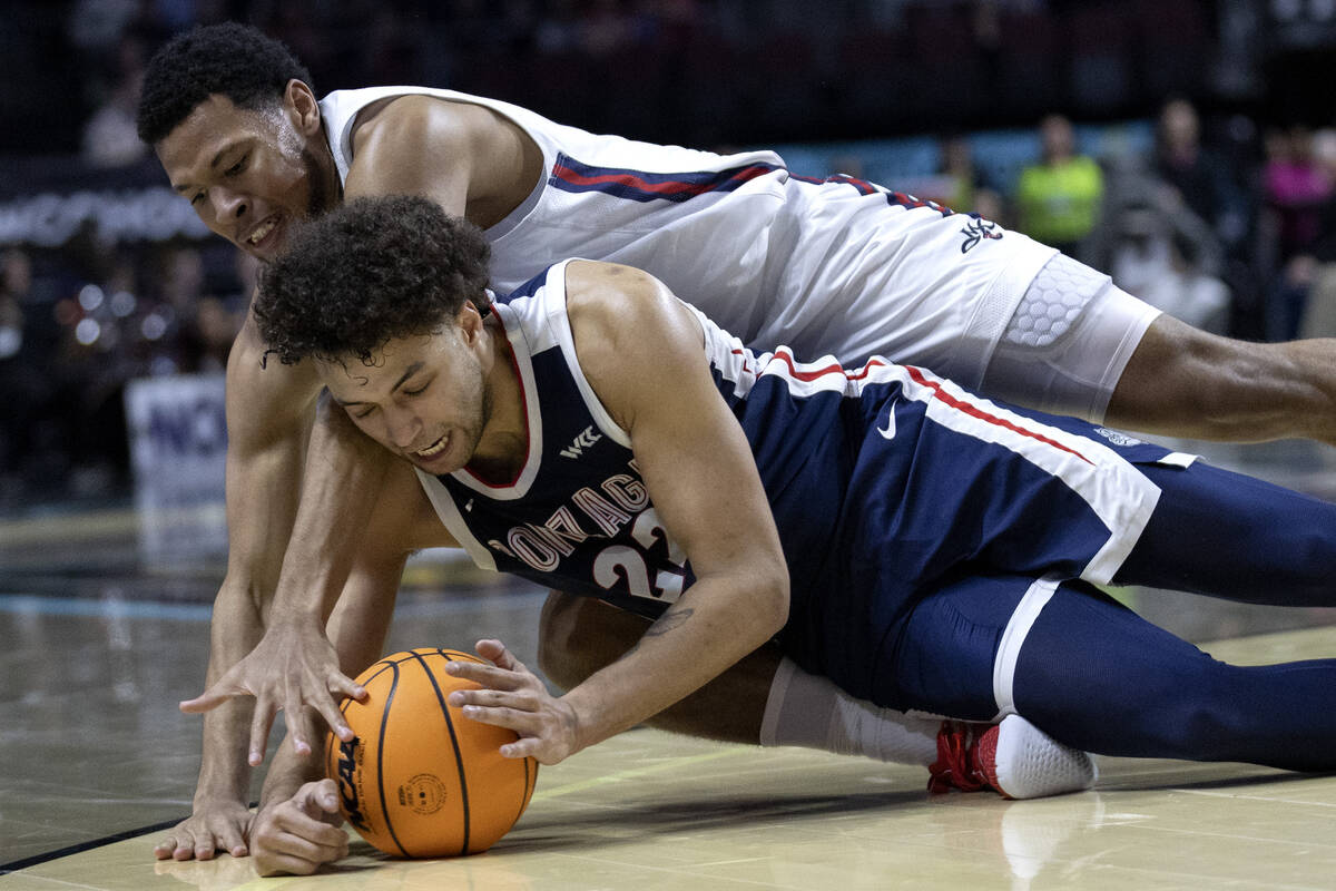 Gonzaga Bulldogs forward Anton Watson (22) dives for the ball to steal possession from St. Mary ...