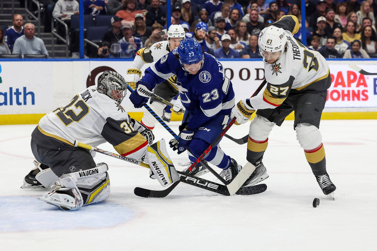 Vegas Golden Knights' Shea Theodore (27) checks Tampa Bay Lightning's Michael Eyssimont (23) in ...