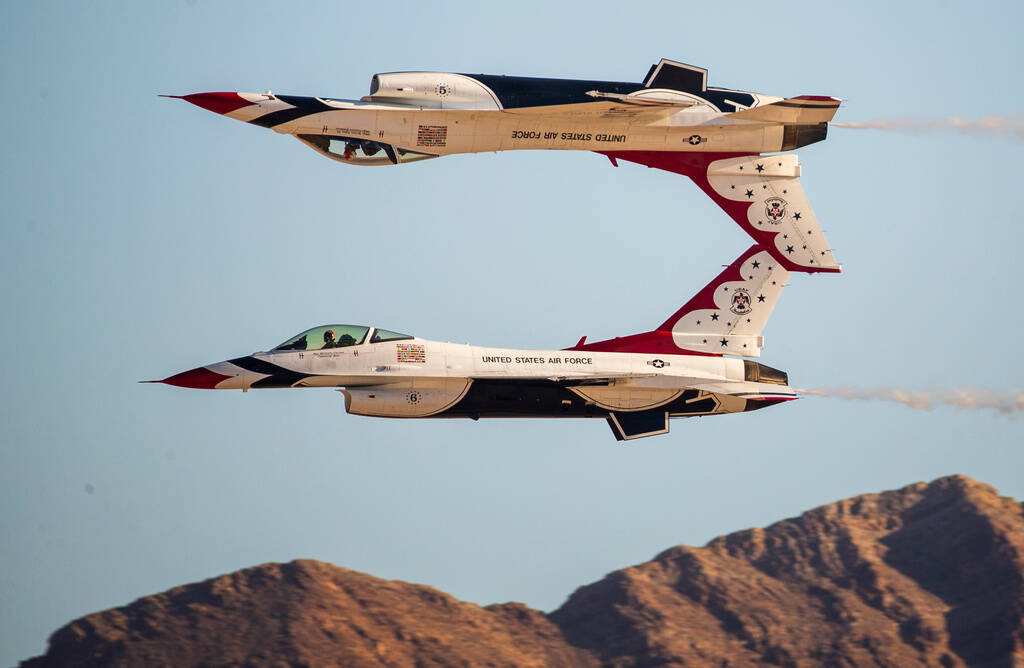 Two U.S. Air Force Thunderbird jets, with one inverted, fly during a performance at the Aviatio ...