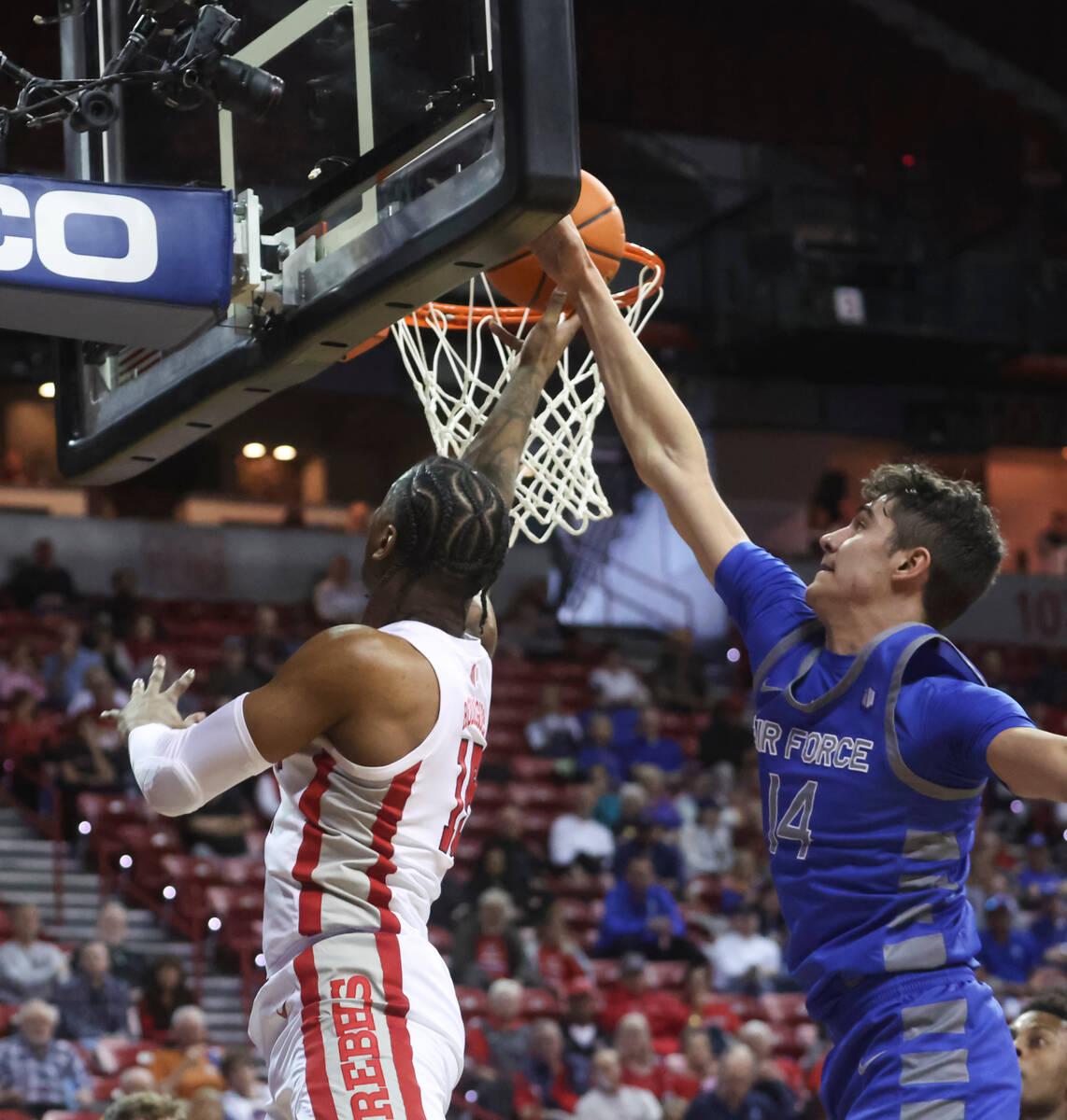 UNLV guard Luis Rodriguez (15) lays up the ball past Air Force forward Beau Becker (14) during ...