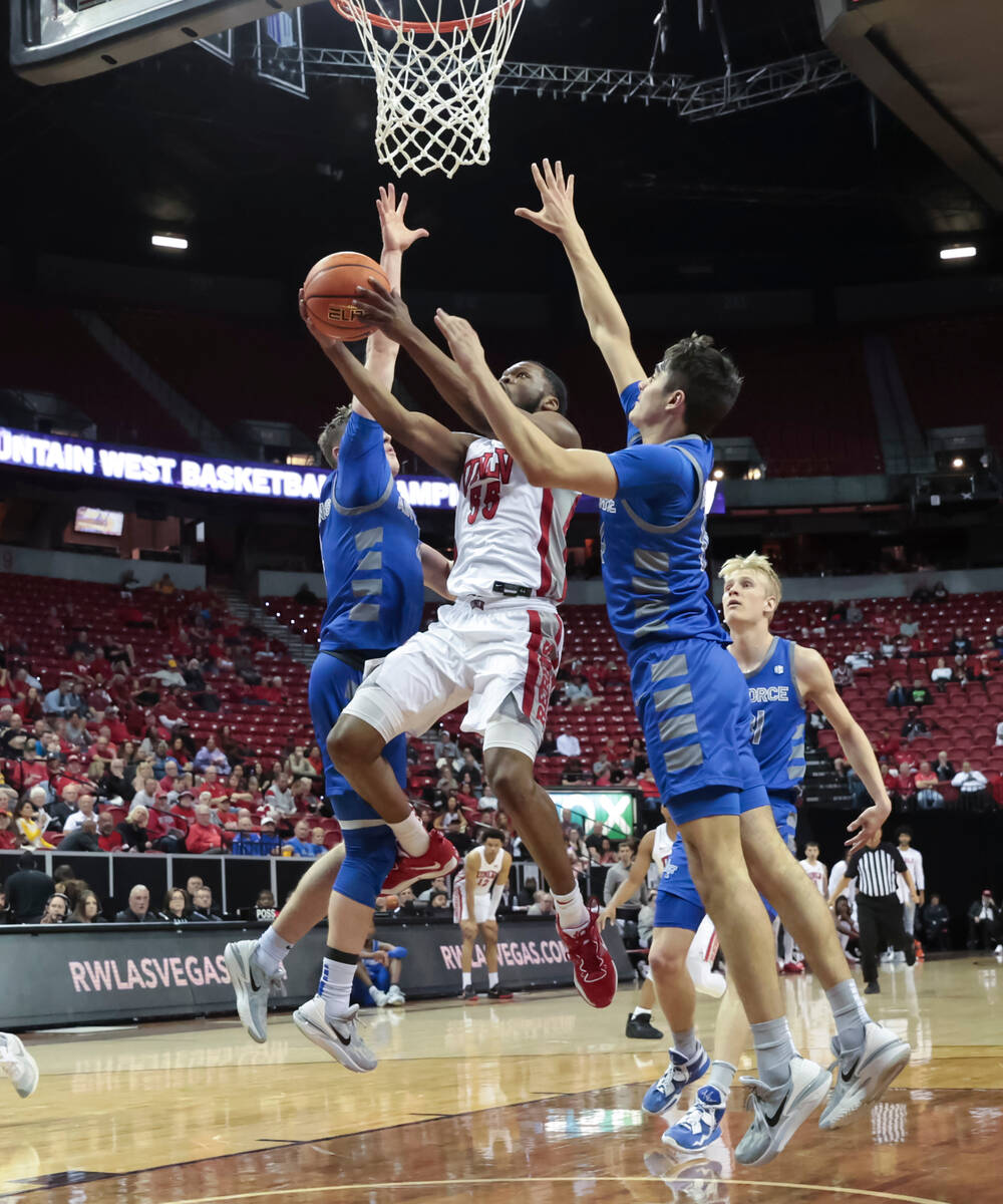 UNLV guard EJ Harkless (55) lays up the ball between Air Force guard Carter Murphy, left, and f ...
