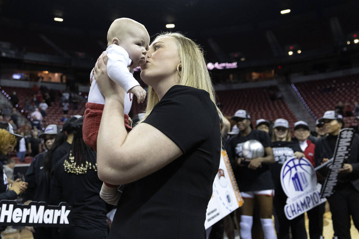 UNLV Lady Rebels head coach Lindy La Rocque kisses her baby Ellie Cunningham after her team won ...