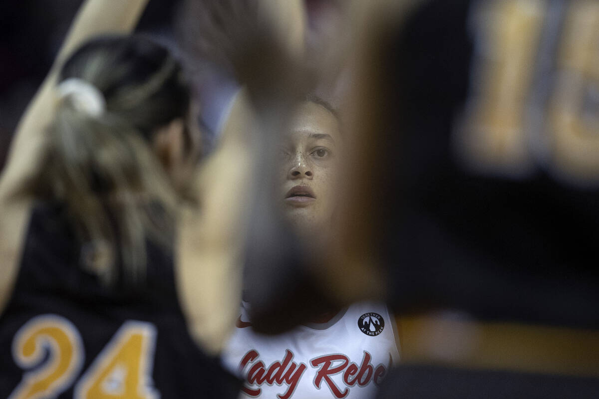 UNLV Lady Rebels guard Kiara Jackson, center, looks for a way to the basket between the Wyoming ...