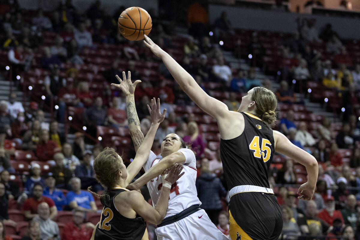 UNLV Lady Rebels guard Essence Booker (24) falls back while shooting against Wyoming Cowgirls g ...