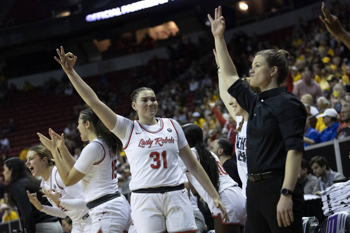 The UNLV Lady Rebels bench including center Erica Collins (31) celebrates after their team scor ...