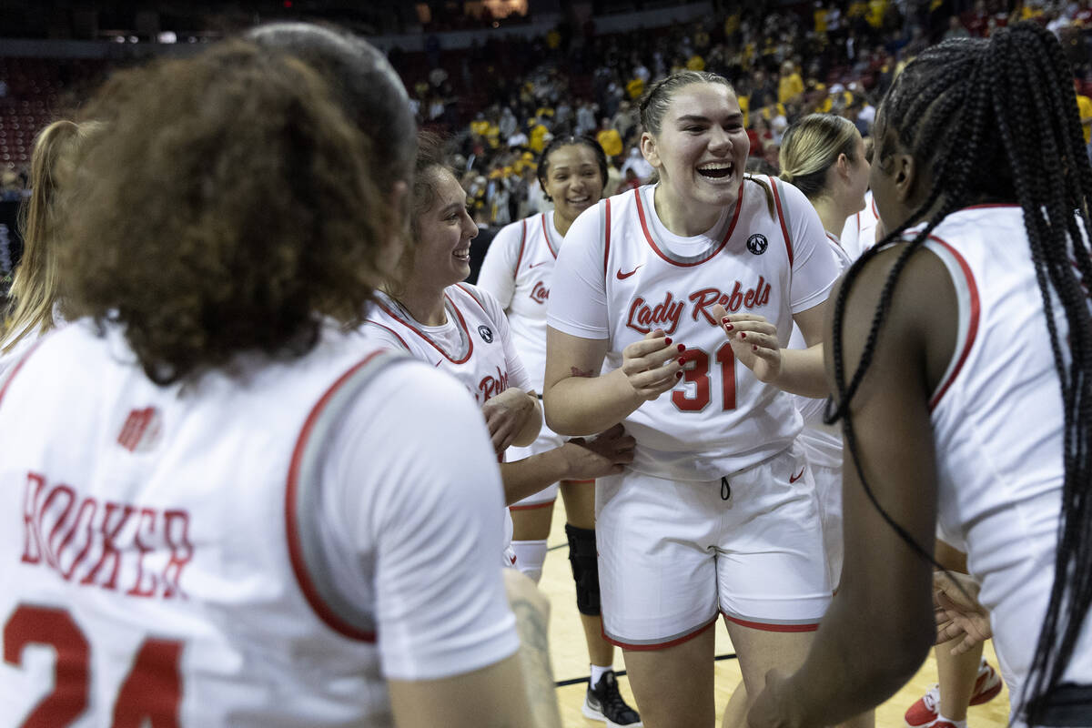 UNLV Lady Rebels center Erica Collins (31) moves in to celebrate with Lady Rebels stars Essence ...