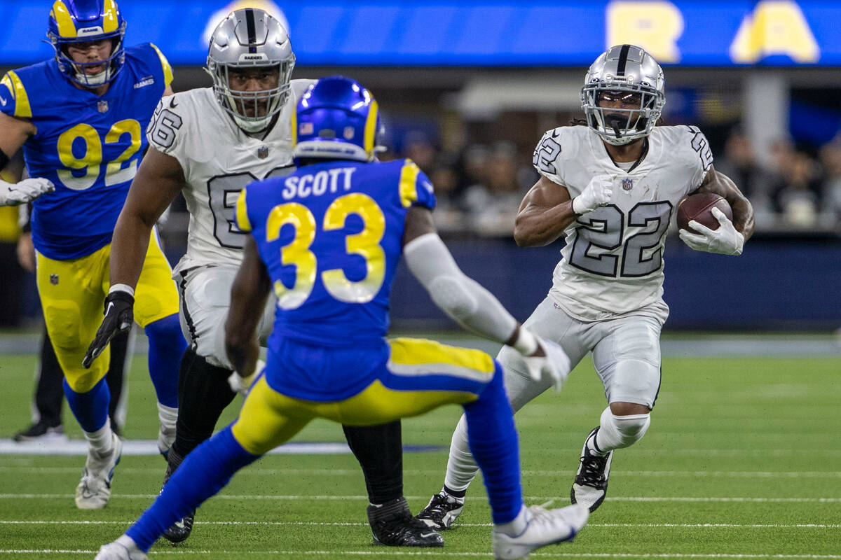 Raiders running back Ameer Abdullah (22) runs as Los Angeles Rams safety Nick Scott (33) defend ...