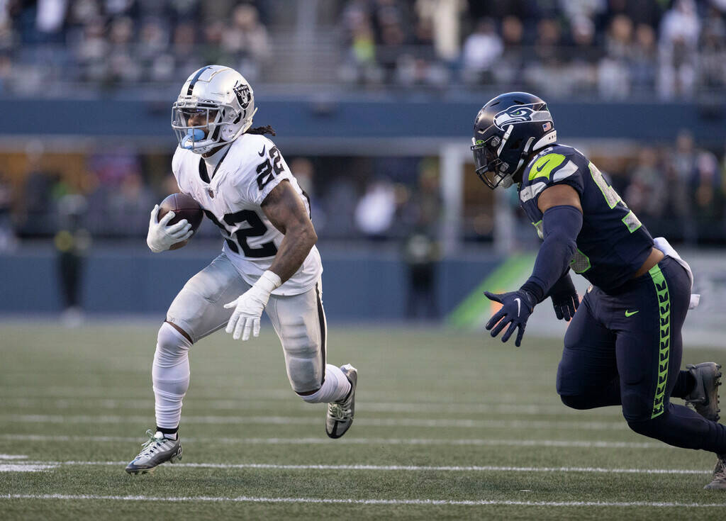 Raiders running back Ameer Abdullah (22) looks for room to run against Seattle Seahawks linebac ...