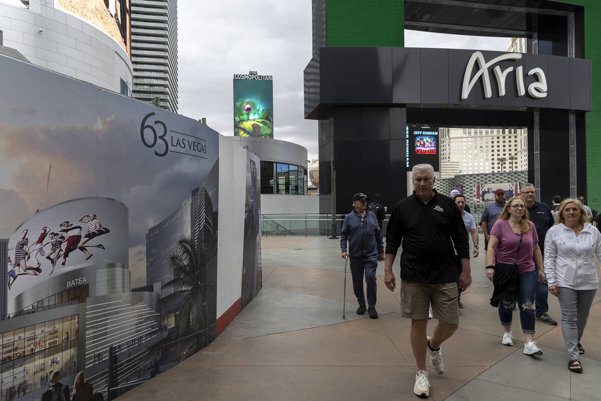 Pedestrians pass signs for 63, a new retail complex at the intersection of Las Vegas Boulevard ...