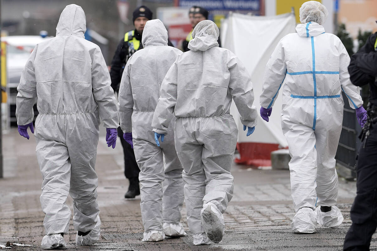 Forensic experts walk to a Jehovah's Witness building in Hamburg, Germany, on Friday, March 10, ...