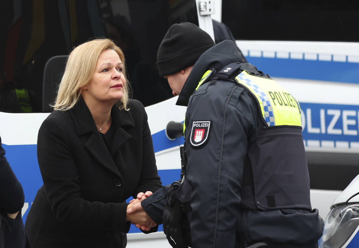 Germany's Interior Minister Nancy Faeser, left, shakes hands with a police officer in Hamburg, ...