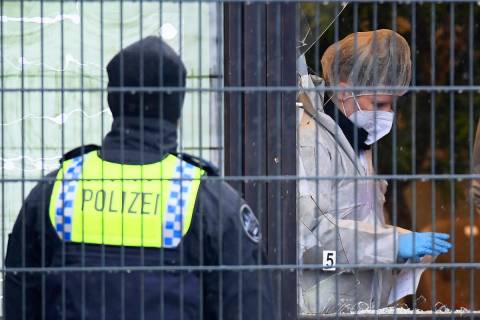 Investigators and forensic experts stand outside a Jehovah's Witness building in Hamburg, Germa ...