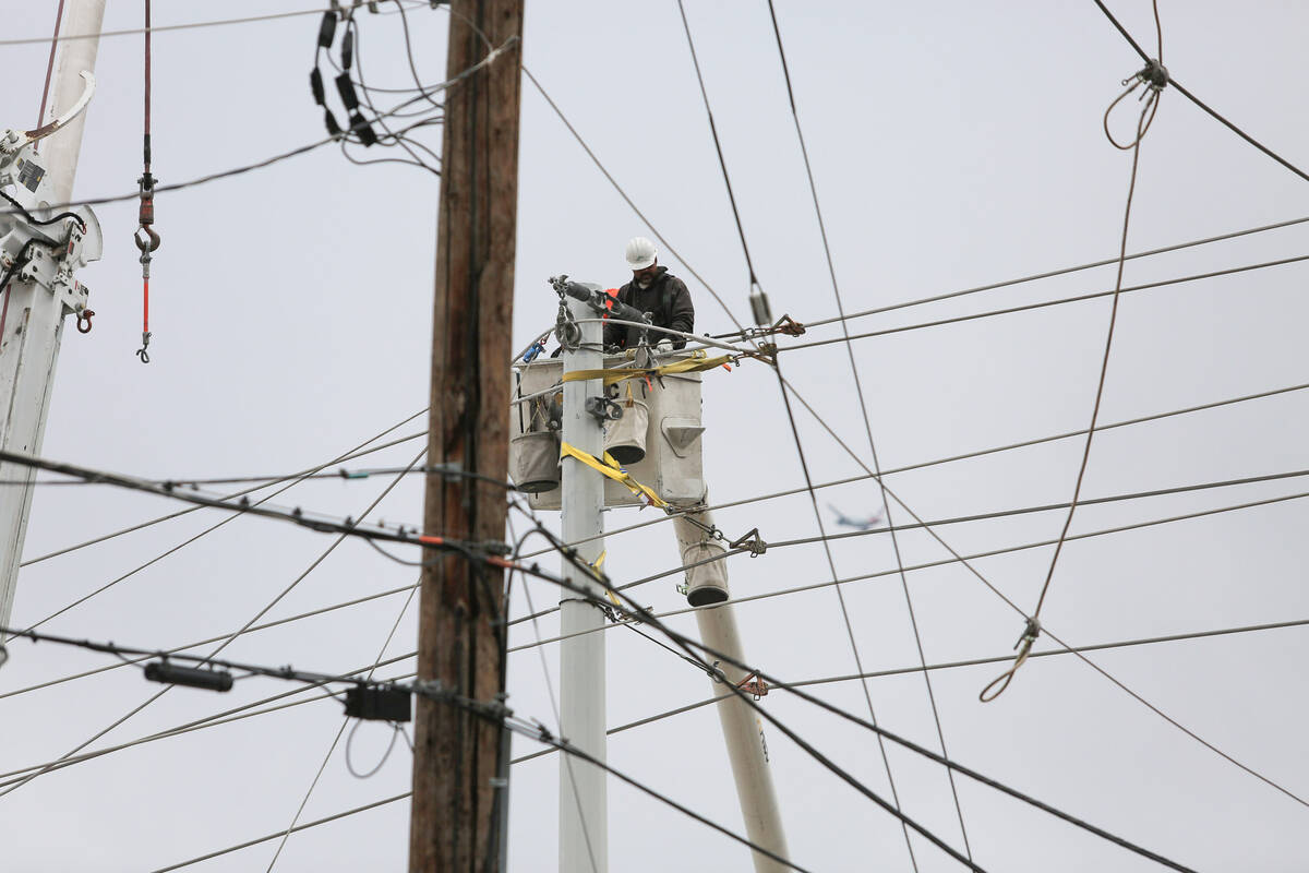 NV Energy workers fix downed power lines at the intersection of Harmon Avenue and Koval Lane ne ...