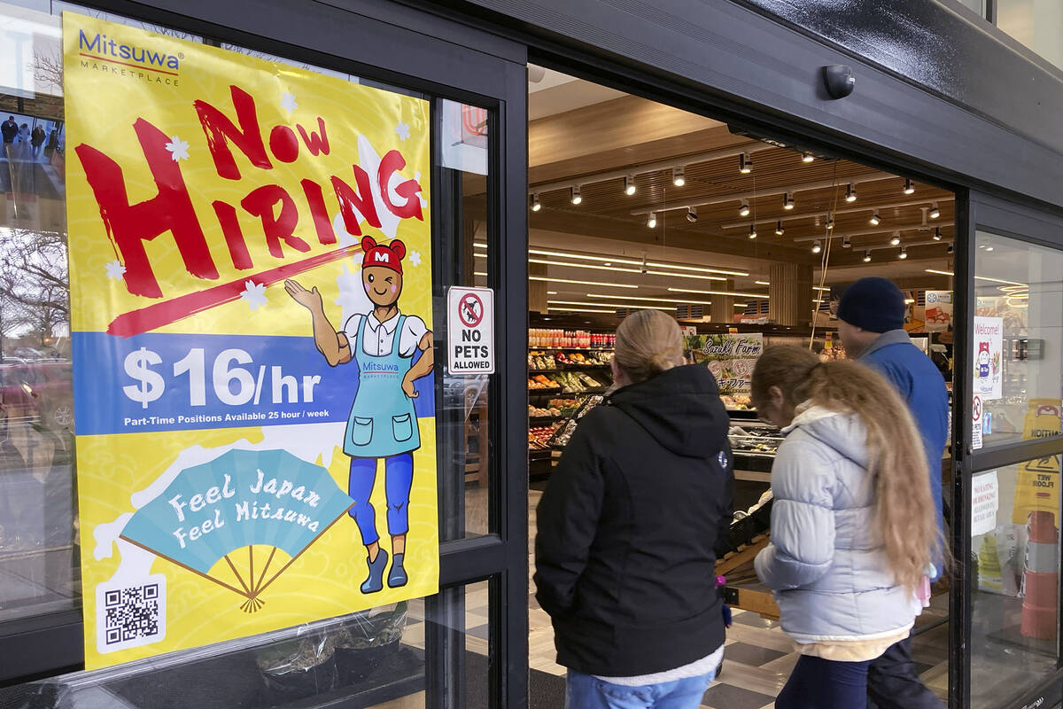 FILE - A hiring sign is displayed at a grocery store in Arlington Heights, Ill., Friday, Jan. 1 ...