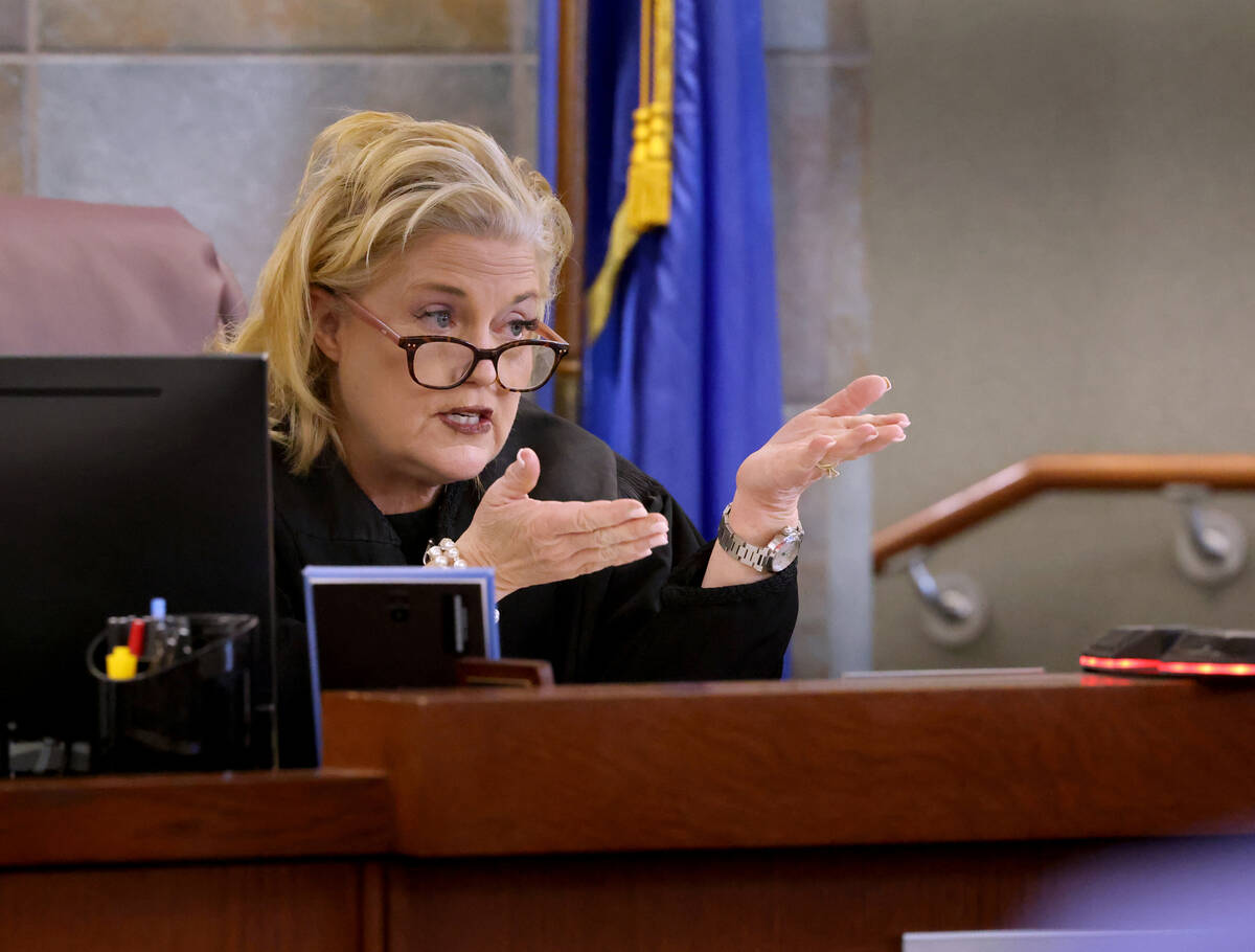 District Judge Michelle Leavitt converses with former Clark County Administrator Robert Telles, ...
