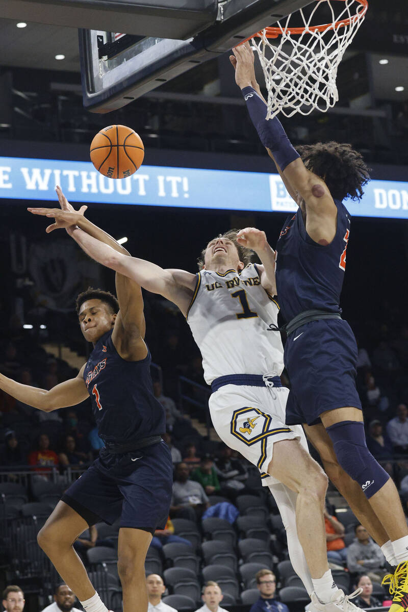 UC Irvine Anteaters guard Dawson Baker (1) attempts a jump shot as Cal State Fullerton Titans g ...