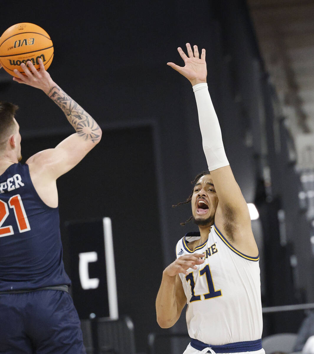Cal State Fullerton Titans guard Grayson Carper (21) looks to pass against UC Irvine Anteaters ...