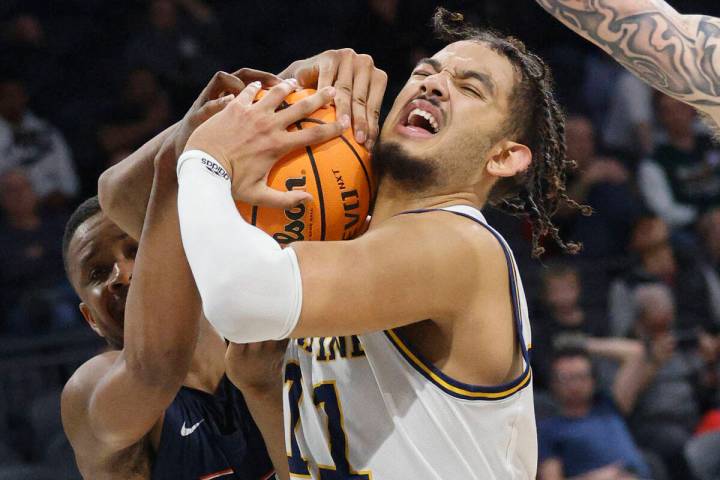 Cal State Fullerton Titans guard Jalen Harris (0), left, and UC Irvine Anteaters forward Devin ...