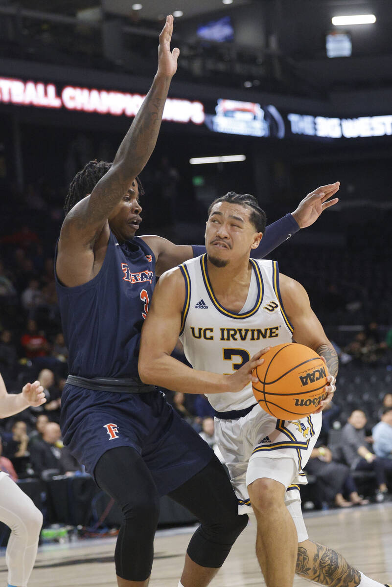 UC Irvine Anteaters guard Pierre Crockrell II (3) drives to the basket as Cal State Fullerton T ...