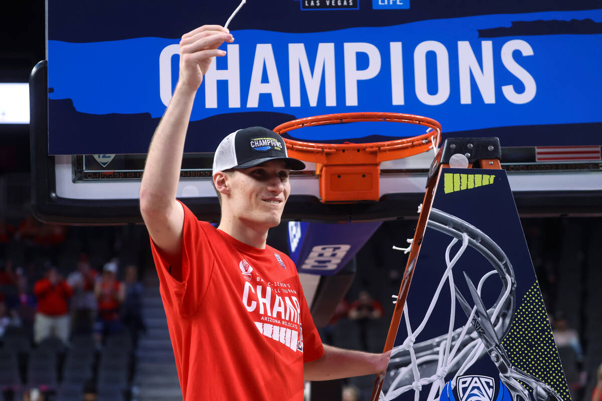 Arizona forward Azuolas Tubelis holds up a piece of the net after the team's win over UCLA in a ...
