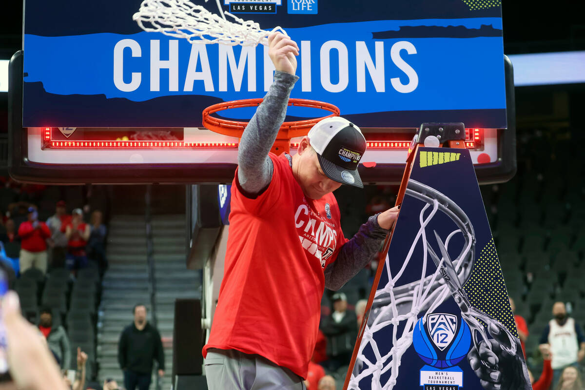 Arizona head coach Tommy Lloyd celebrates with the net after defeating UCLA in an NCAA college ...