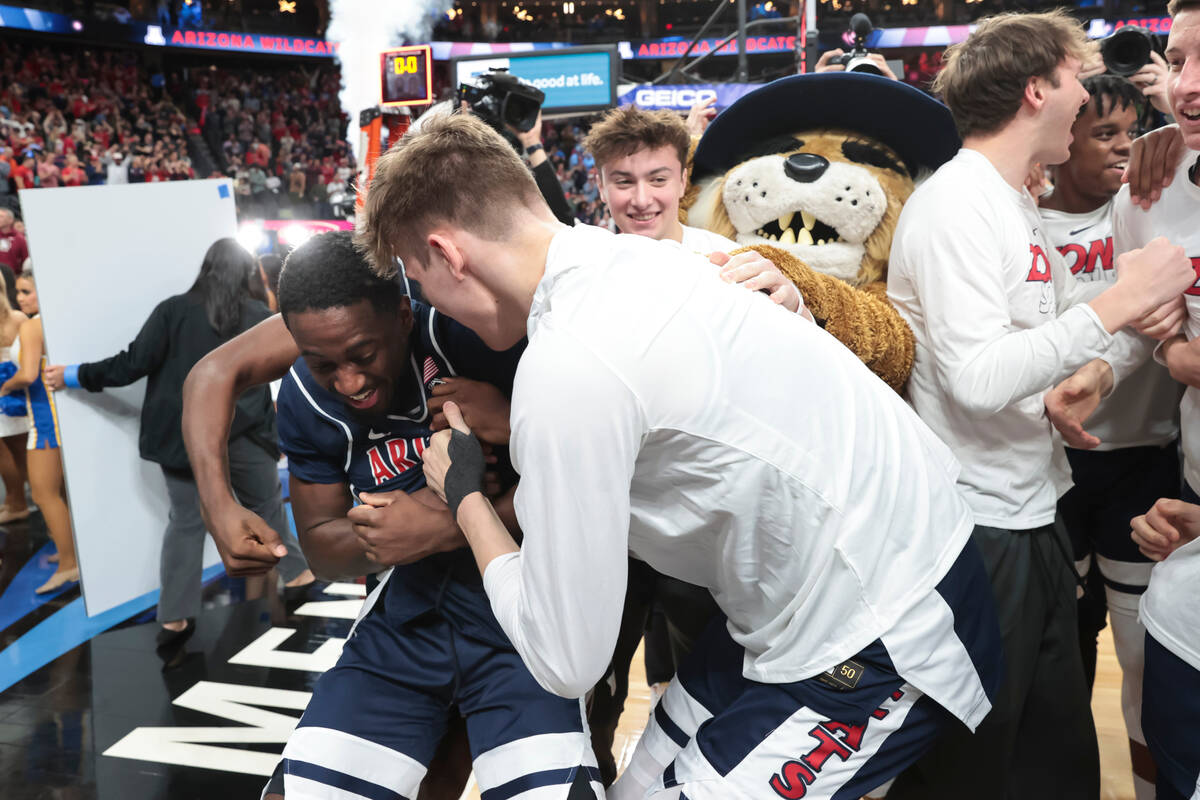 Arizona guard Courtney Ramey, left, celebrates with teammates after their win over UCLA in an N ...