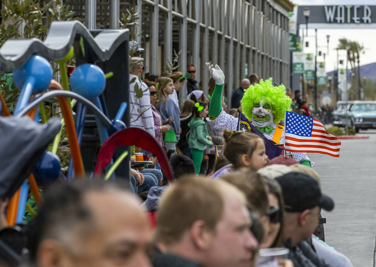 A clown with the Zelzah Shriners waves to the crowd along the parade route down Water Street du ...