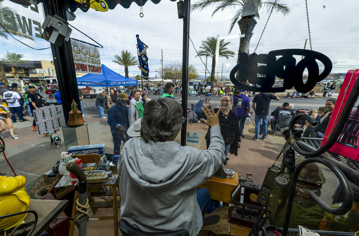 Cindy Simmons waves to attendees as she sits in the window of Gold Casters Jewelry during the p ...