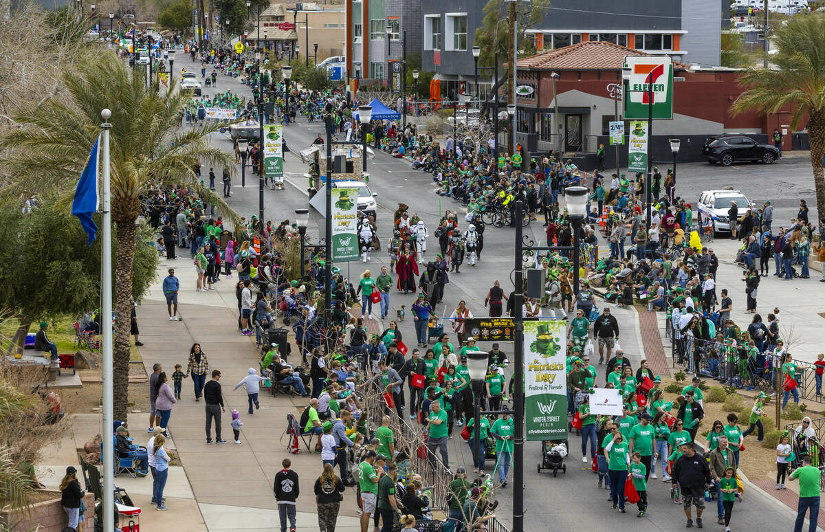 Participants make their way on the parade route down Water Street during the St. Patrick&#x2019 ...