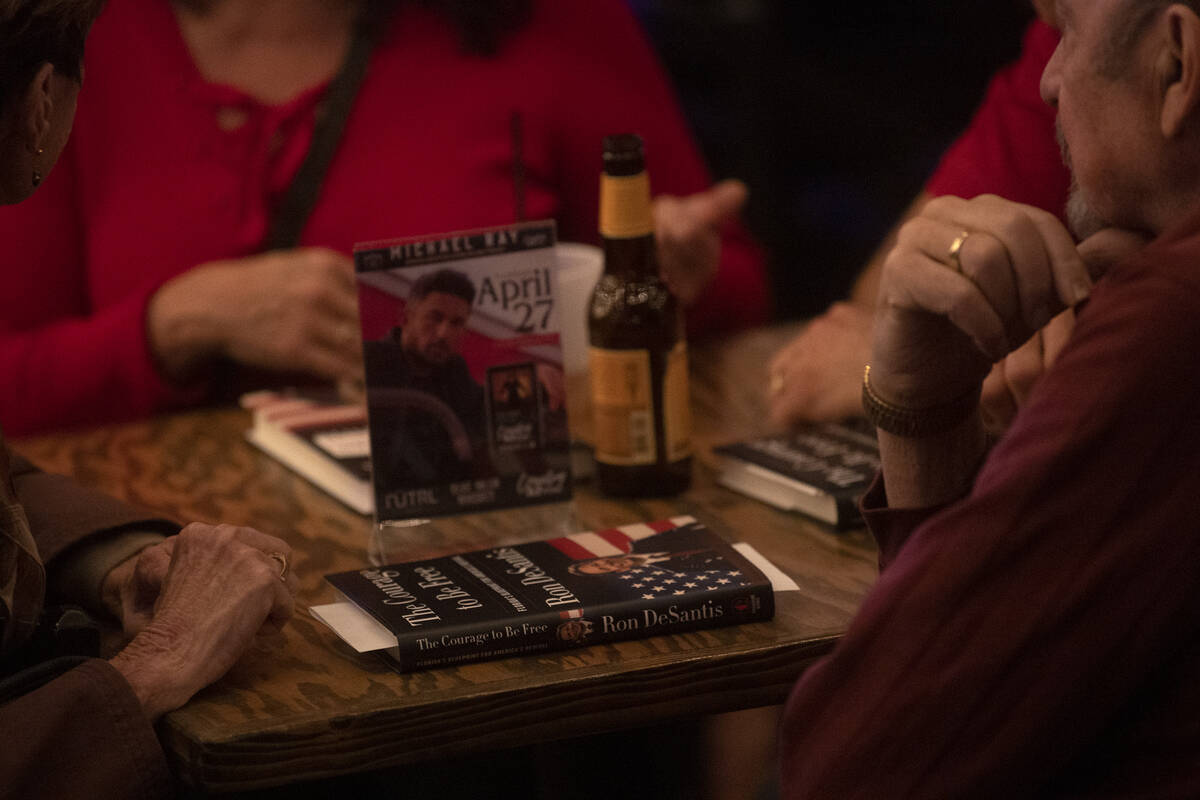 Attendees of an event on Florida Gov. Ron DeSantis’ book tour wait for the governor to s ...