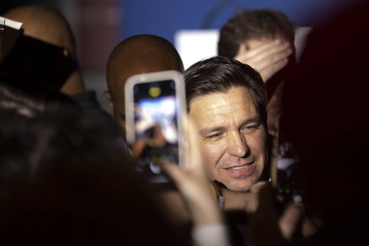 Florida Gov. Ron DeSantis is surrounded by supporters after speaking during a stop on his book ...
