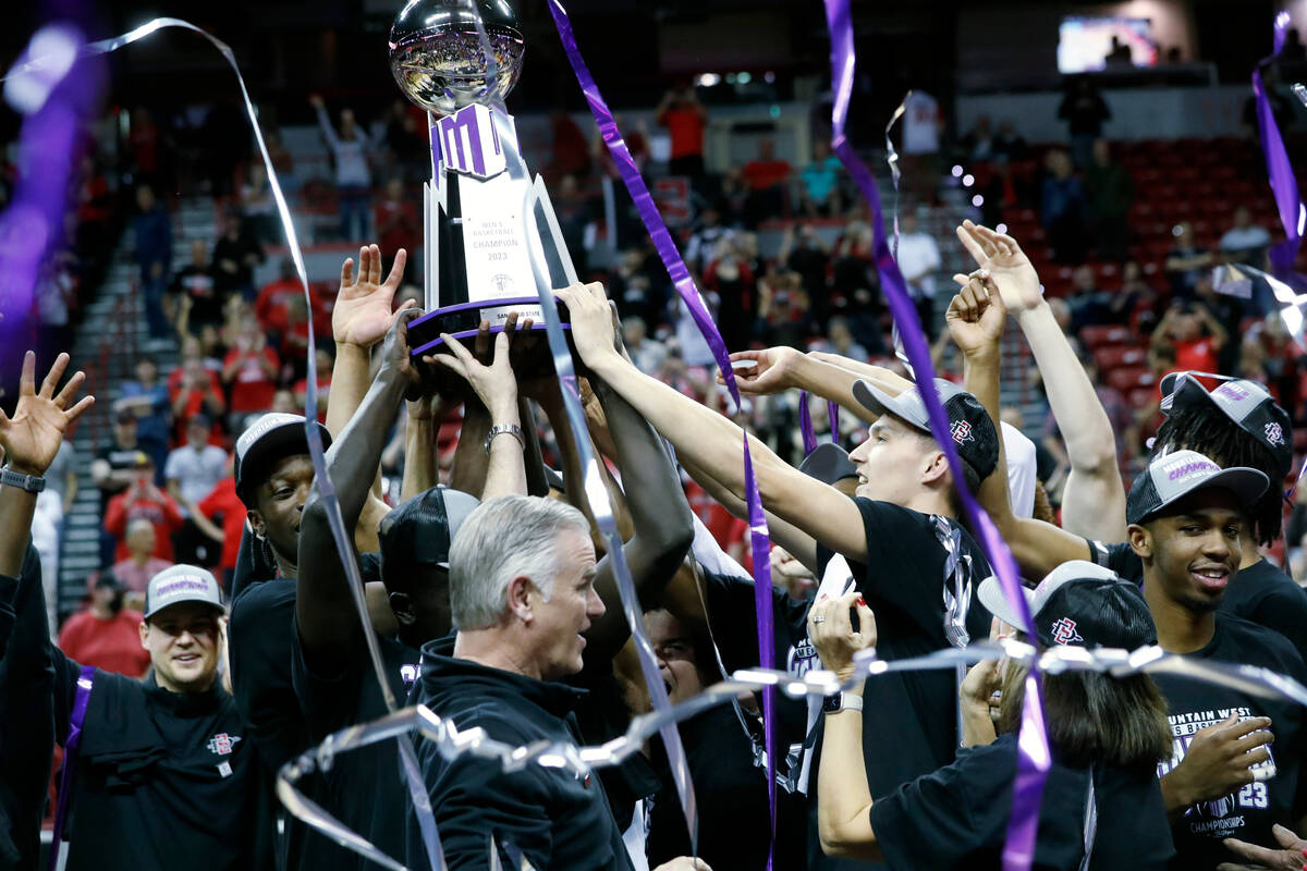San Diego State players and coach Brian Dutcher, bottom center, celebrate their victory over Ut ...