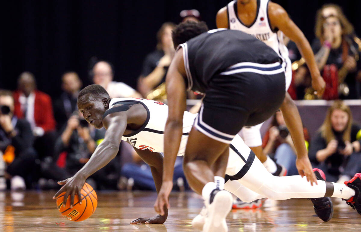 San Diego State forward Aguek Arop, left, dives for the ball in front of Utah State guard RJ Ey ...