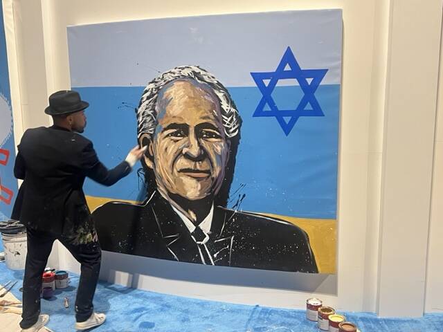 Las Vegas artist Ricardo Barraza is shown finishing a portrait of the late Sheldon Adelson at t ...