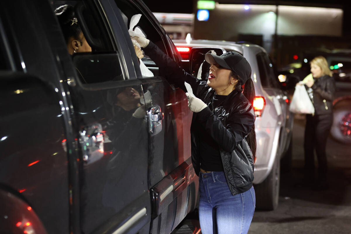 Maria Mendoza delivers food to customers during a buyout event in support of the taco street ve ...