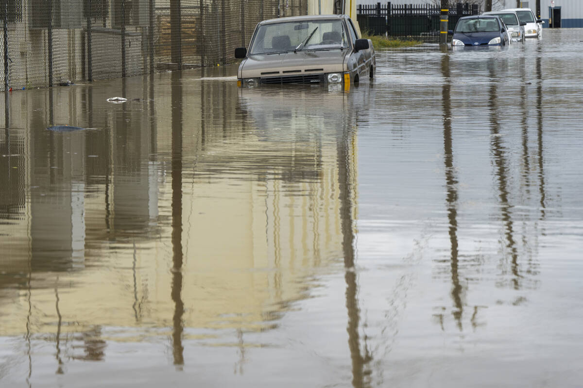 Cars are partially submerged in floodwaters in Watsonville, Calif., Saturday, March 11, 2023. ( ...