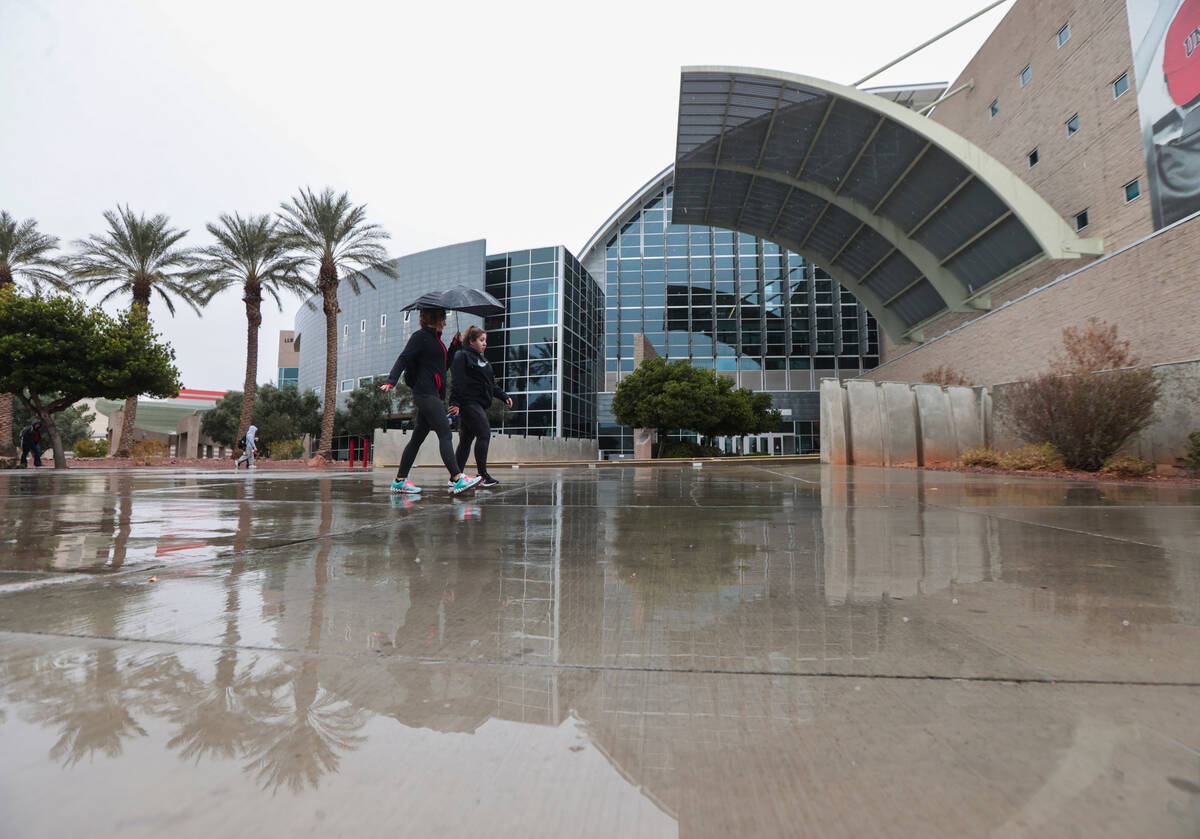 People walk on the UNLV campus as rain comes down on Tuesday, March 14, 2023, in Las Vegas. (Ch ...