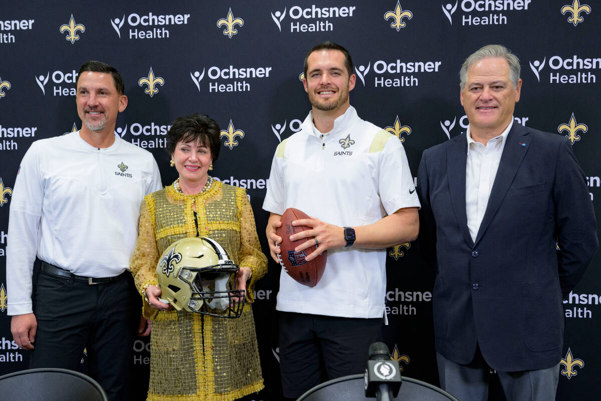 Derek Carr, second right, the new quarterback of the New Orleans poses with Saints general mana ...