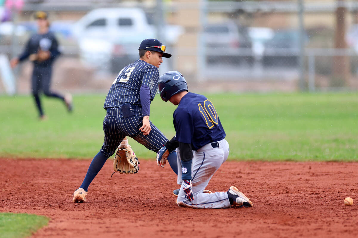 Spring Valley's Eddy Zurita (13) drops the ball as Boulder City's Ian Aldridge (10) slides to s ...