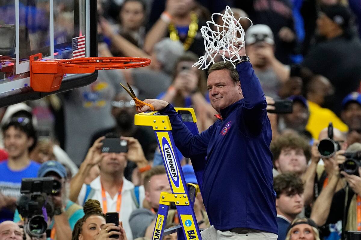 Kansas head coach Bill Self holds the net after a college basketball game against North Carolin ...
