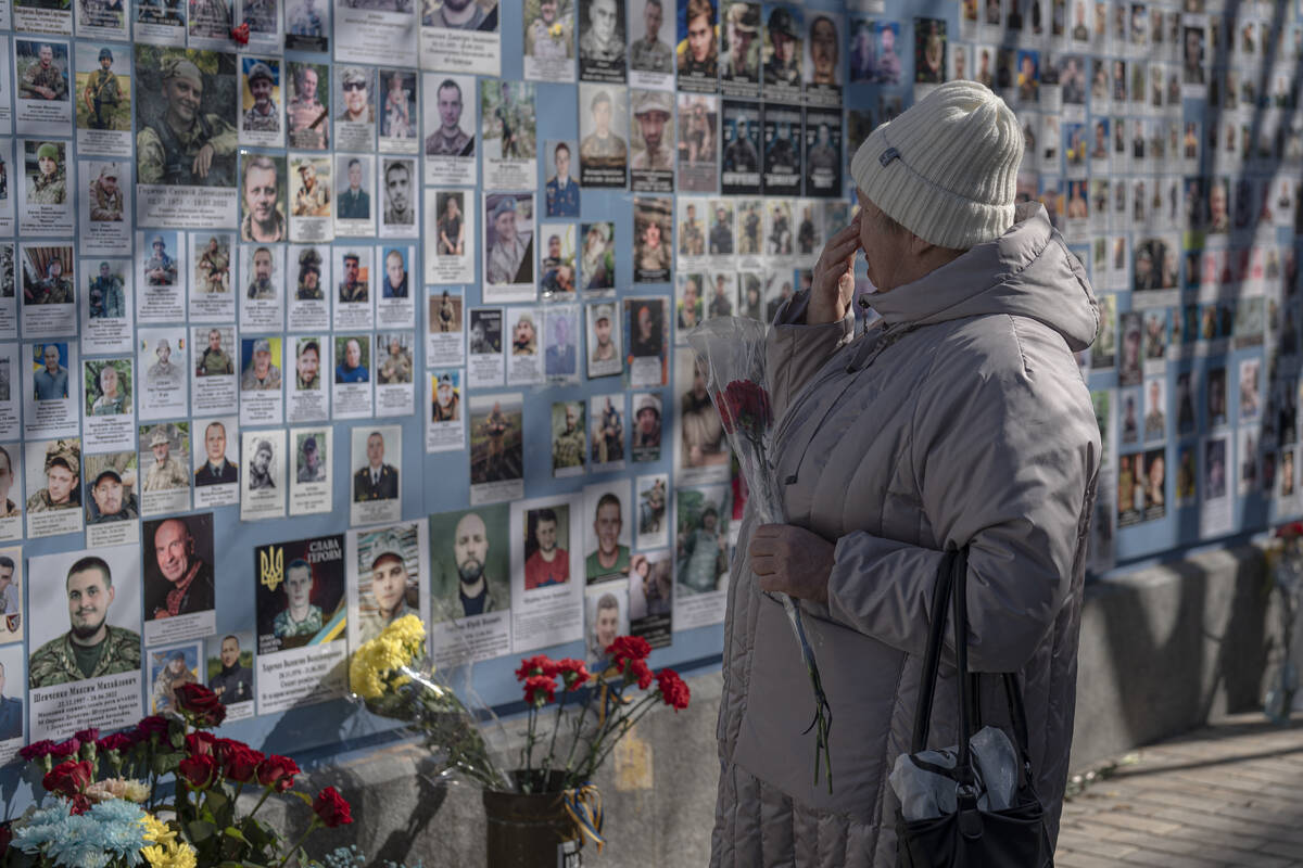 A woman watches the Memory Wall of Fallen Defenders of Ukraine in Russian-Ukrainian War, on Ukr ...