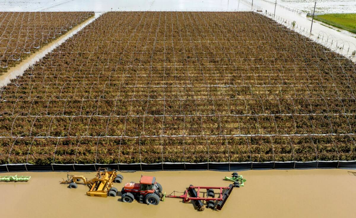 Floodwaters surround farm machinery in the community of Pajaro in Monterey County, Calif., on M ...