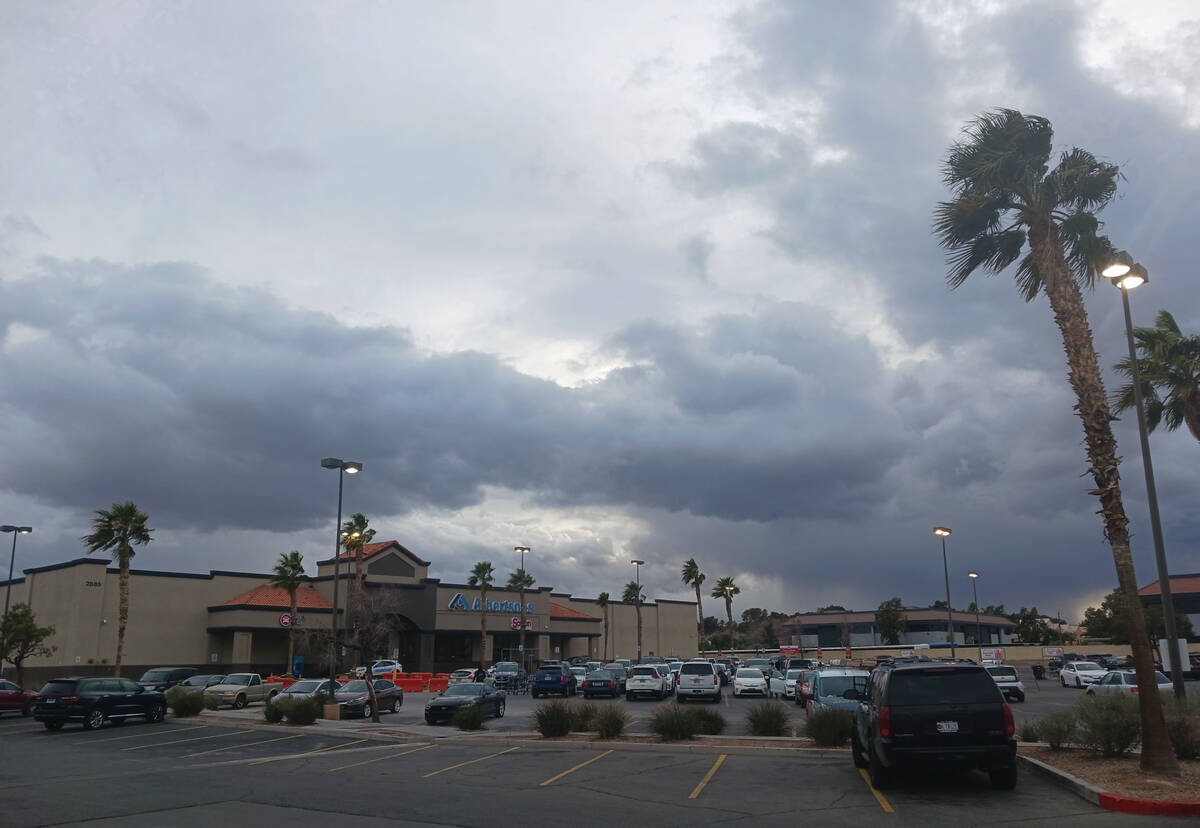 Clouds mostly obscure the setting sun over a shopping plaza near Desert Inn Road and Pecos Driv ...