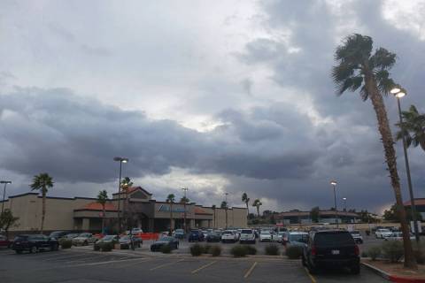 Clouds mostly obscure the setting sun over a shopping plaza near Desert Inn Road and Pecos Driv ...