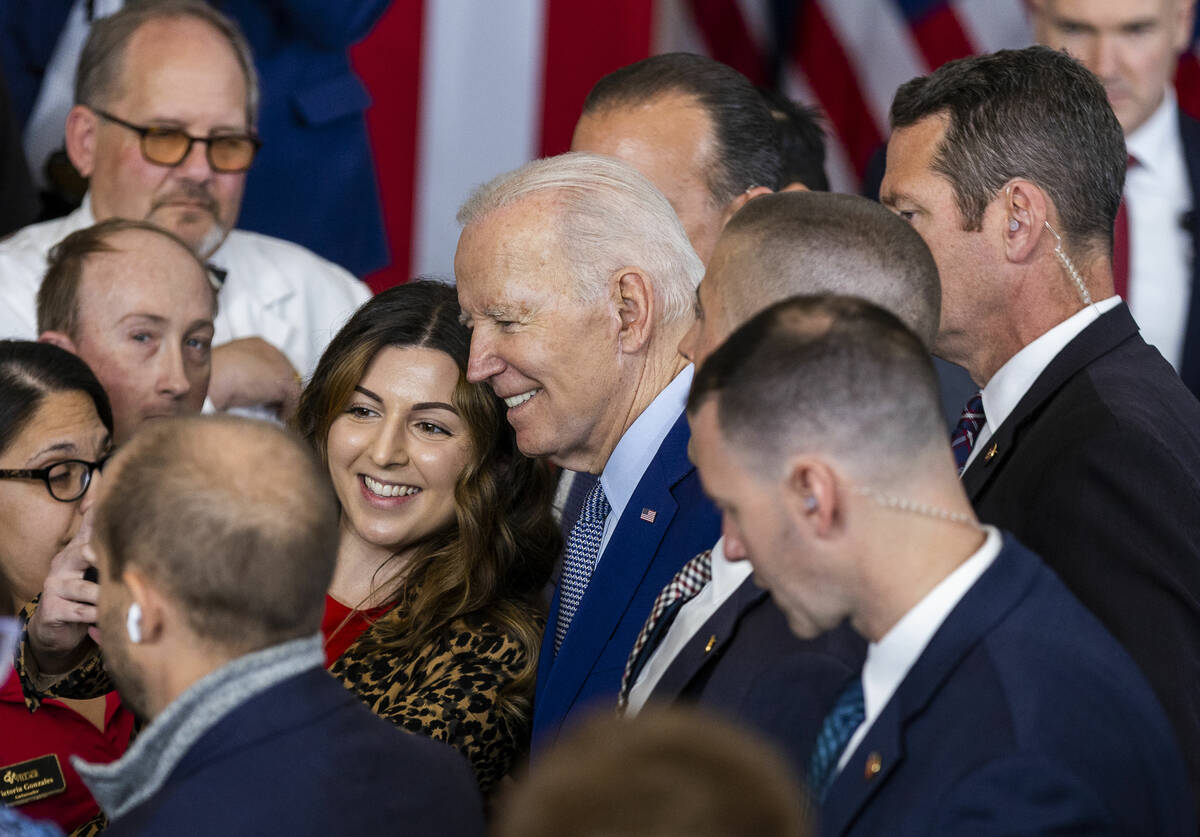 President Joe Biden takes a photo with an attendee after talking about lowering prescription dr ...