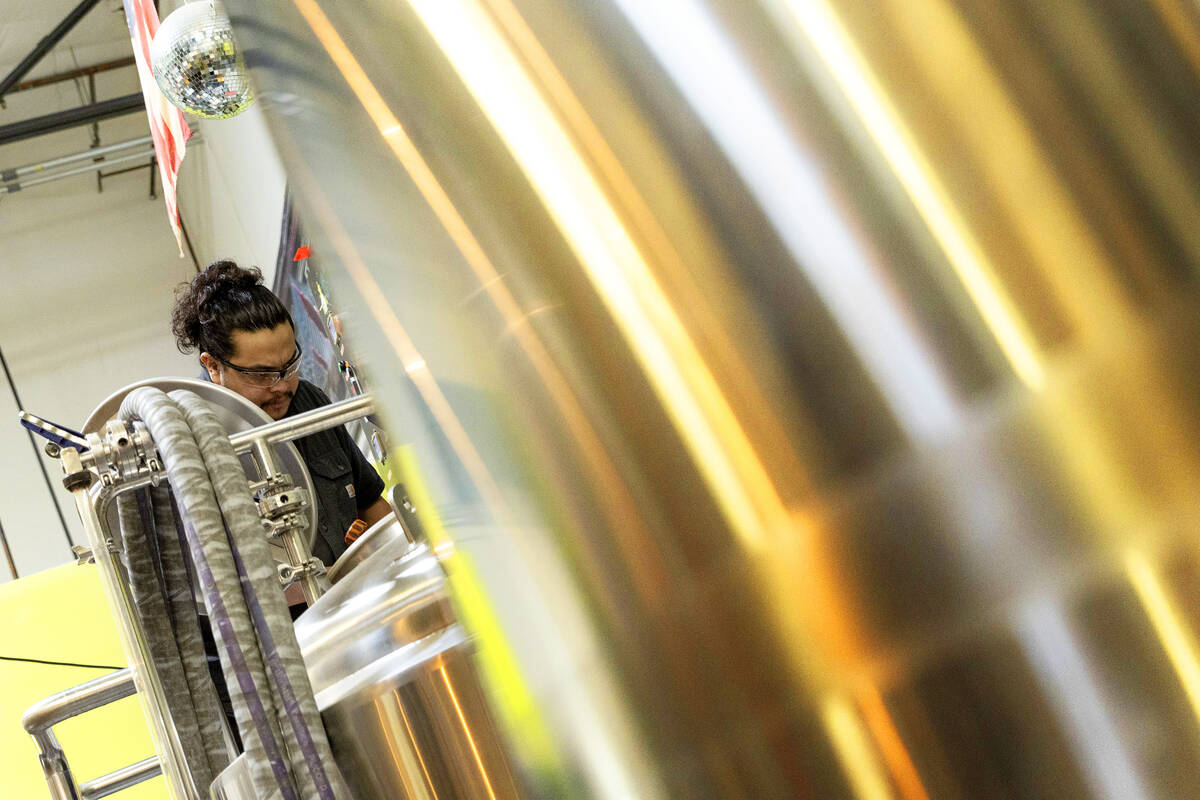 Brewer Mondo Donis completes the mashing process of the Rebel Spirit brew at CraftHaus Brewery ...