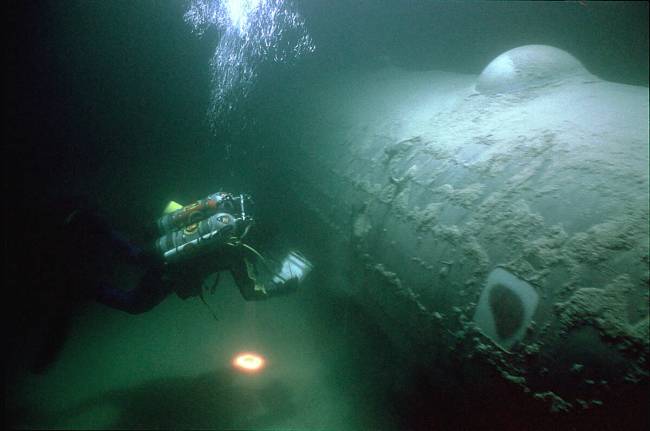 Seorang arkeolog bawah air Layanan Taman Nasional memeriksa pembom B-29, dijuluki "Bom Beatle...