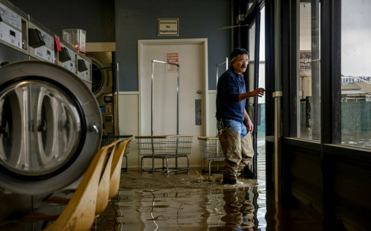 Patrick Cerruti assesses damage of his daughter's flooded laundry mat, Pajaro Coin Laundry, on ...